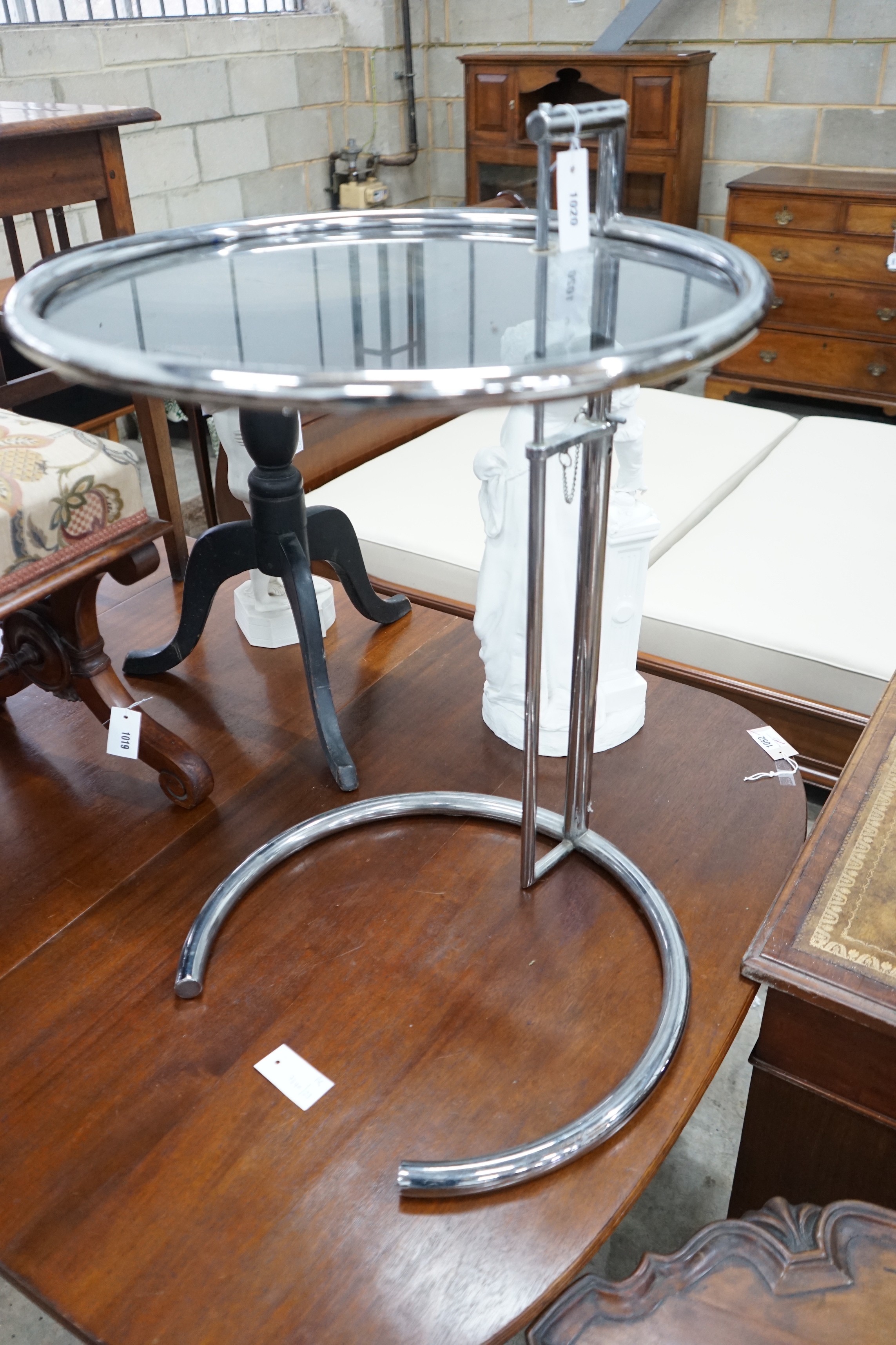 In the style of Eileen Gray - An E 1027 style circular chrome and smoked glass telescopic occasional table, diameter 51cm